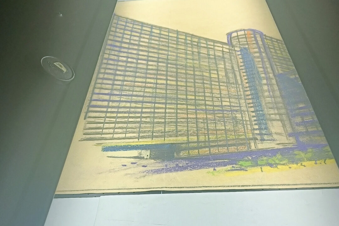 A color architectural drawing of a high-rise building on the CRUSE scanner during the digitization process